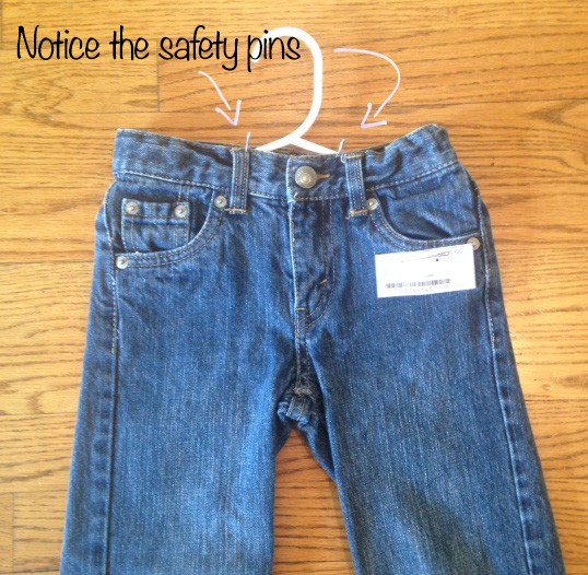 Example of pants pinned to a hanger with two safety pins at the waist